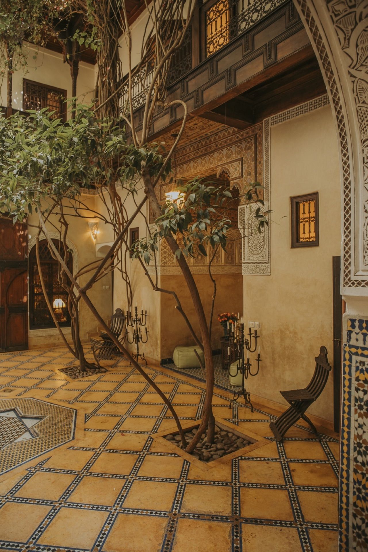 Porte en bois sculpté, banquette kilim et objets marocains au Riad Samsara