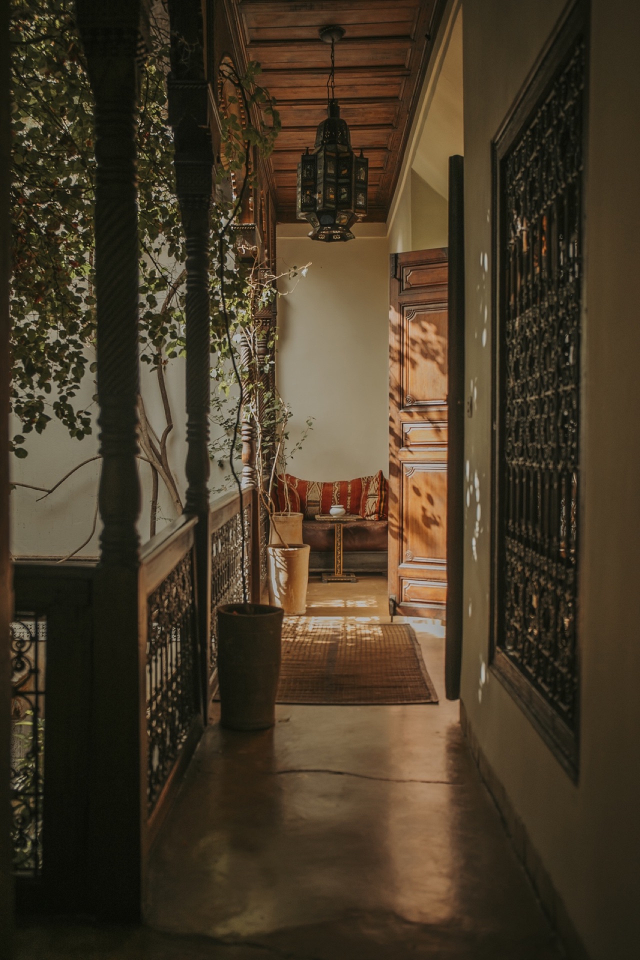 Coursive du riad, lanterne suspendue, moucharabieh et banquette kilim