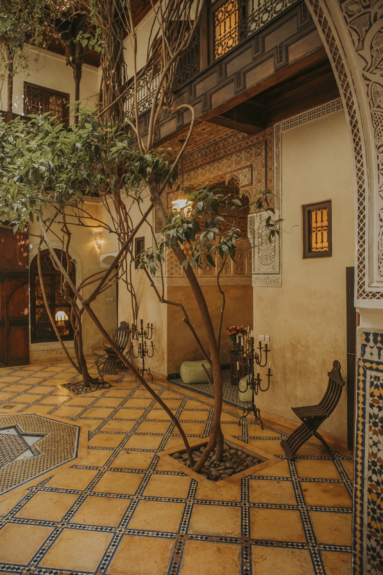 Porte en bois sculpté et banquette kilim dans un angle du riad