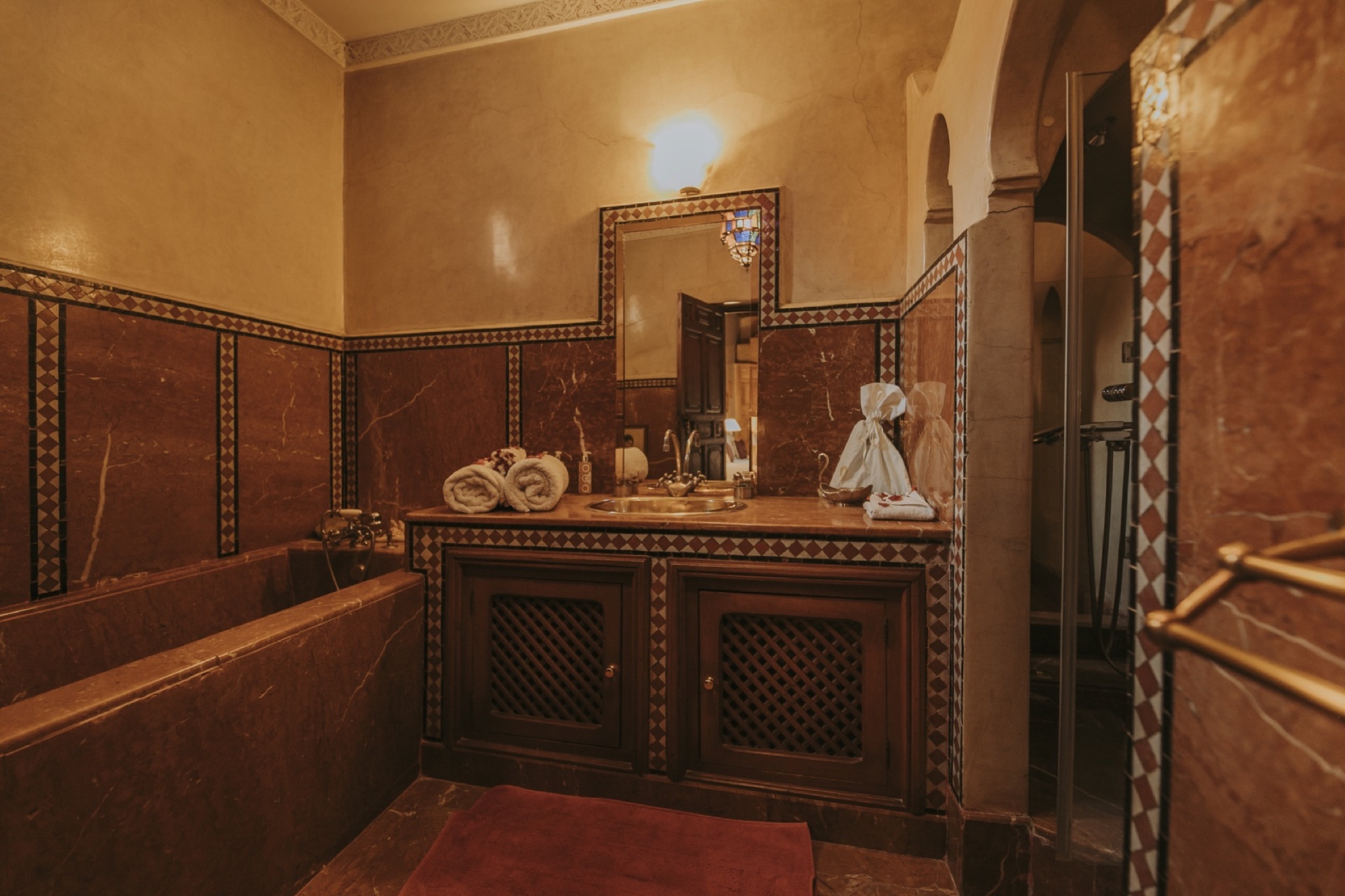 Suite Hibiscus — salle de bain en marbre bordeaux et frise de zellige